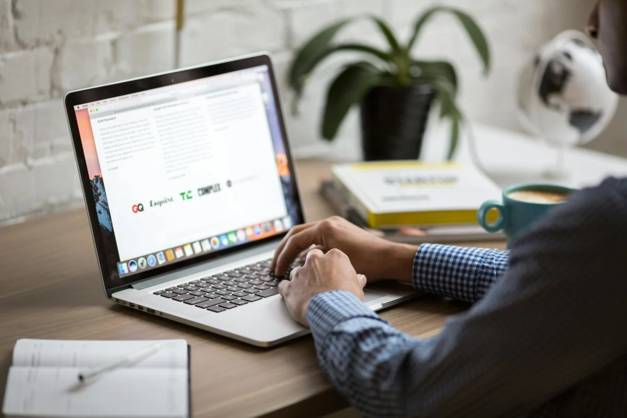 Man sat at an open laptop, representing a worker using AI in the workplace.