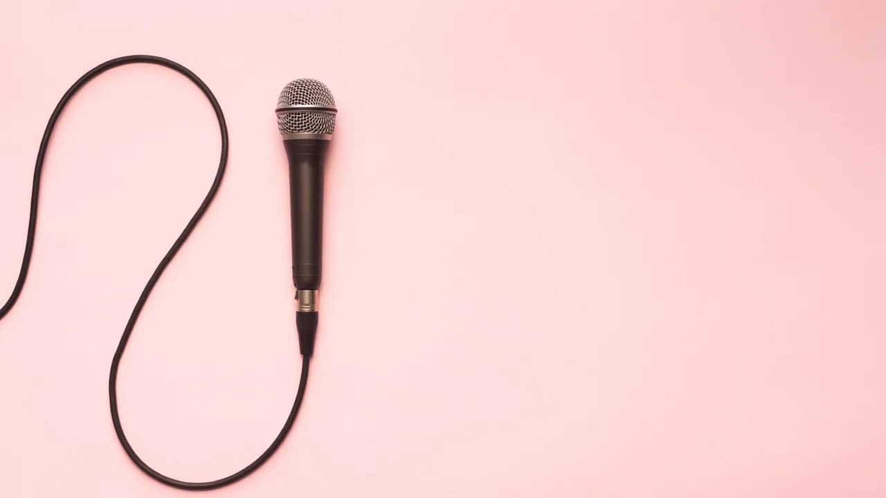 Black microphone on a pink background representing discussing politics in the workplace
