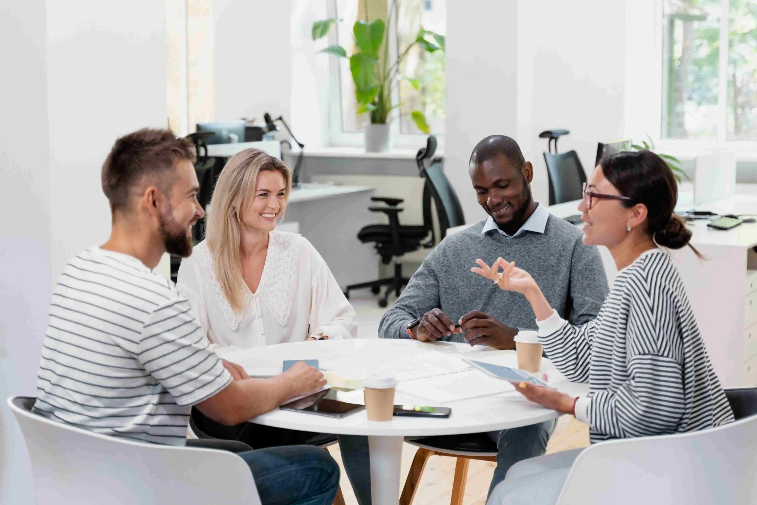 Coworkers seated at table sharing feedback on current knowledge base