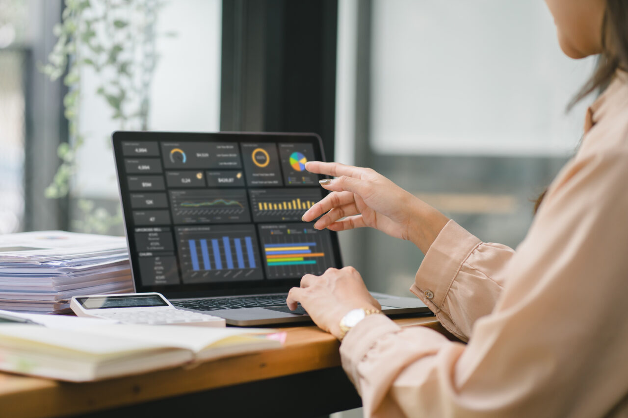 Employee advocacy: A female analyst uses a computer and a dashboard for business data analysis.